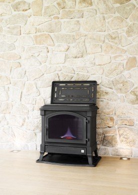 קמין נפט עצמאי פרי סטנד על רקע קיר אבן